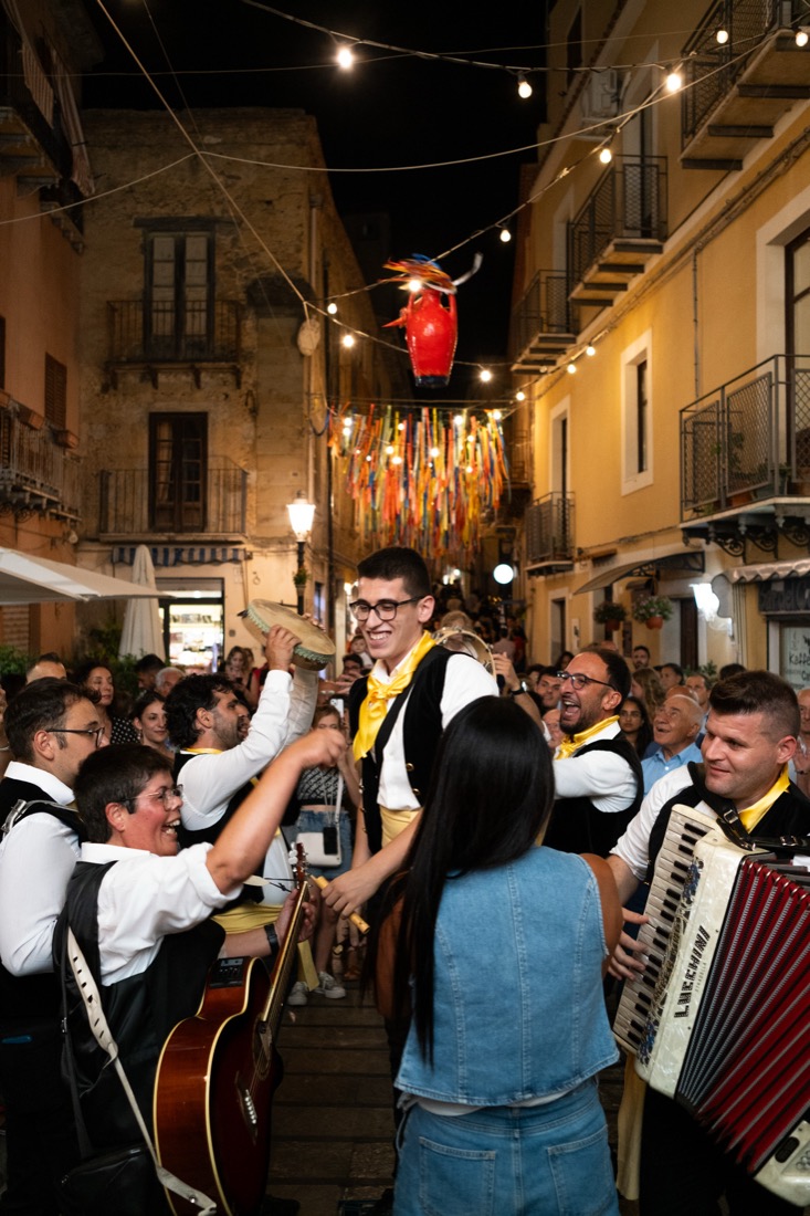 Banda folk tra la folla nel vicolo illuminato